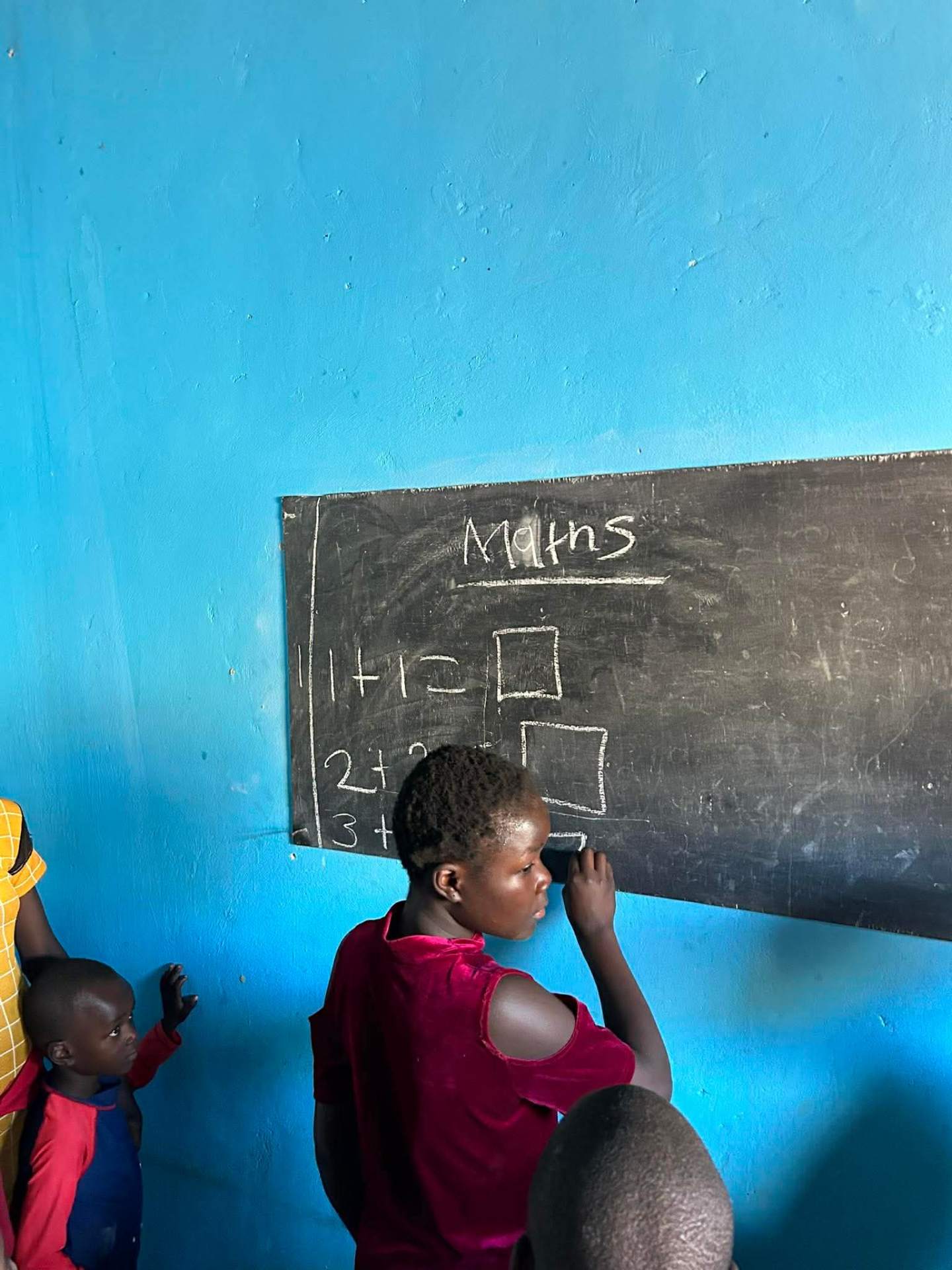 A child writing maths on the chalkboard
