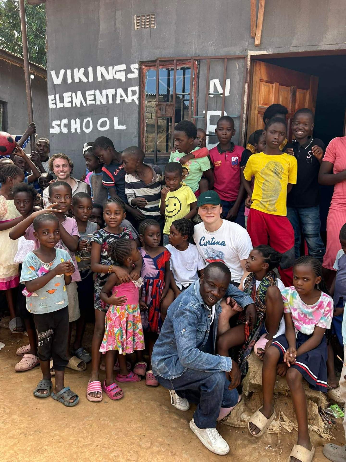 Children of Viking Primary School with founder Mambwe outside the school in Lusaka